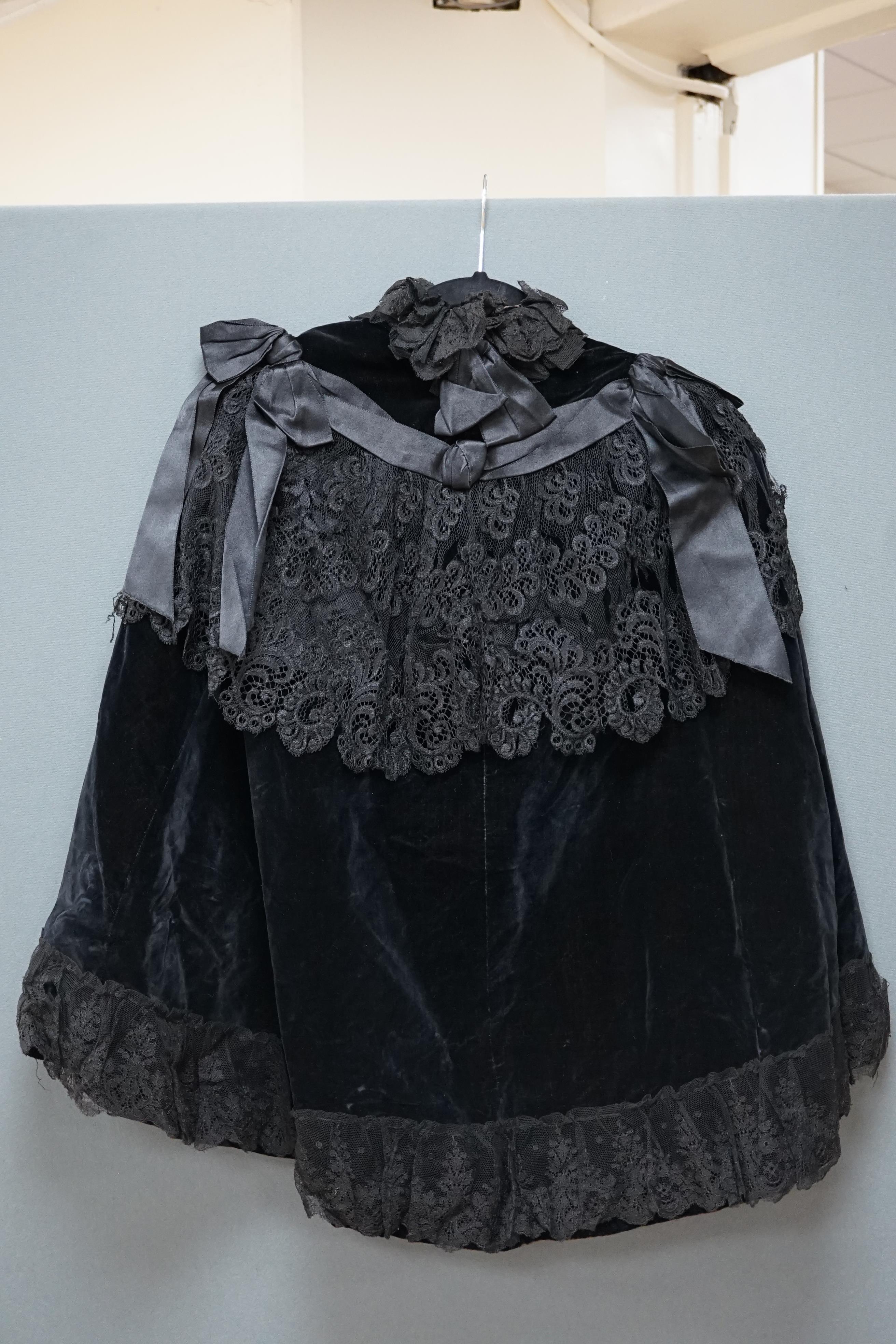 An Edwardian black velvet and black lace evening cape together with a purple chiffon and cream lined blouse labelled John Barker and Co, blouse specialists, Kensington, cape back, neck to bottom edge 72cm. Condition - th